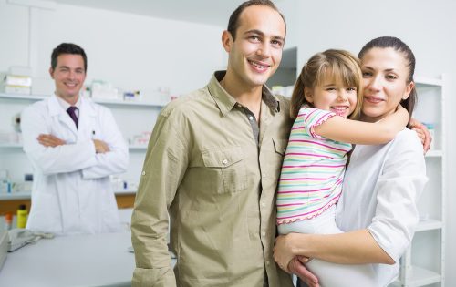 Smiling family and a pharmacist in the pharmacy of a hospital